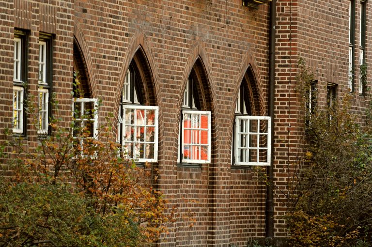 Hausfassade eines historischen Gebäudes der Egestorff Stiftung mit geöffneten Fenstern