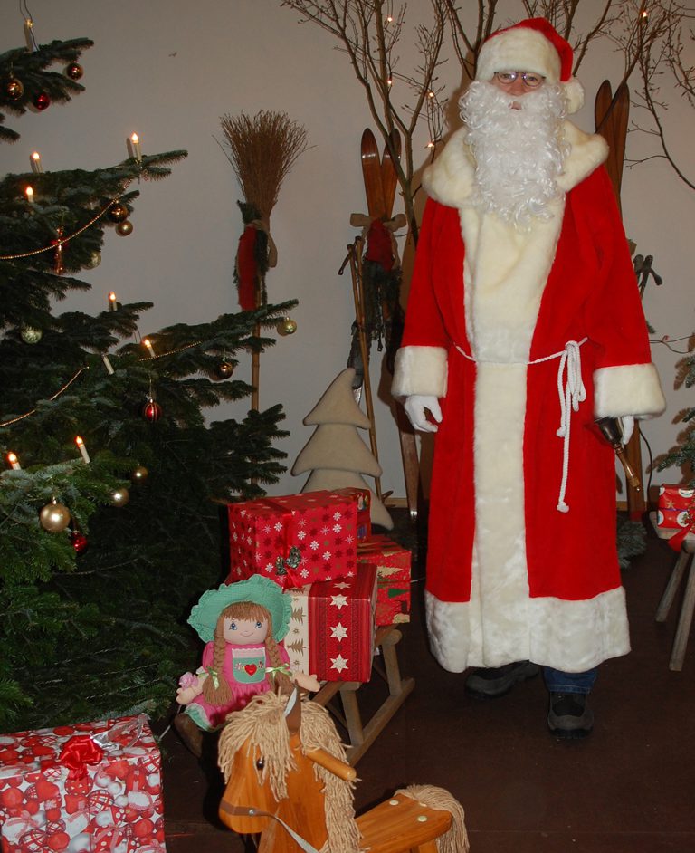 Weihnachtsmann wartet mit Geschenken auf die Bewohnerinnen und Bewohner